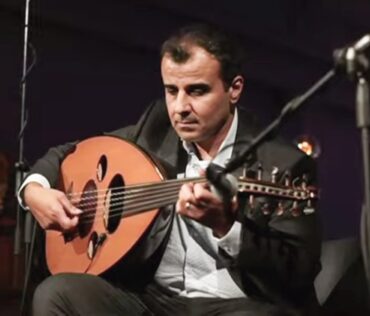 Saife Al-Naffakh playing oud at a concert.